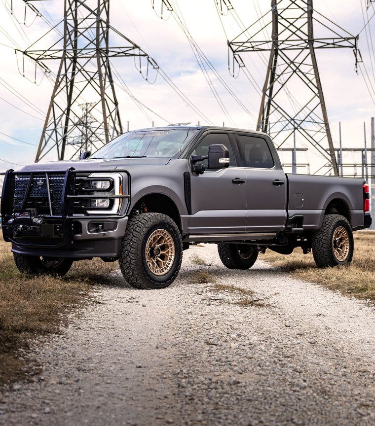 Lifted 2025 Ford F-350 on bronze wheels with a brush guard and winch, built by Apex Custom Innovations
