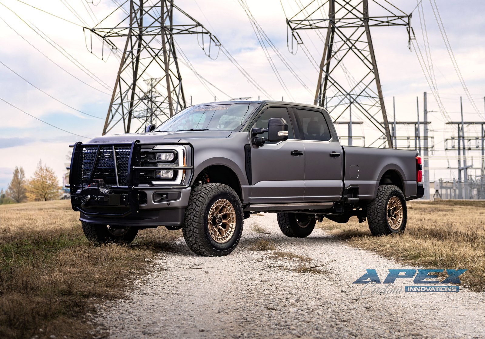 Lifted Ford F-350 on bronze wheels with a brush guard and winch, built by Apex Custom Innovations