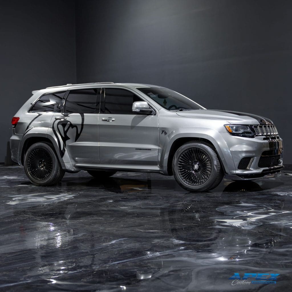 3/4 profile view of a 2021 Jeep Grand Cherokee Trackhawk with silver vinyl wrap and widebody kit by Apex Custom Innovations