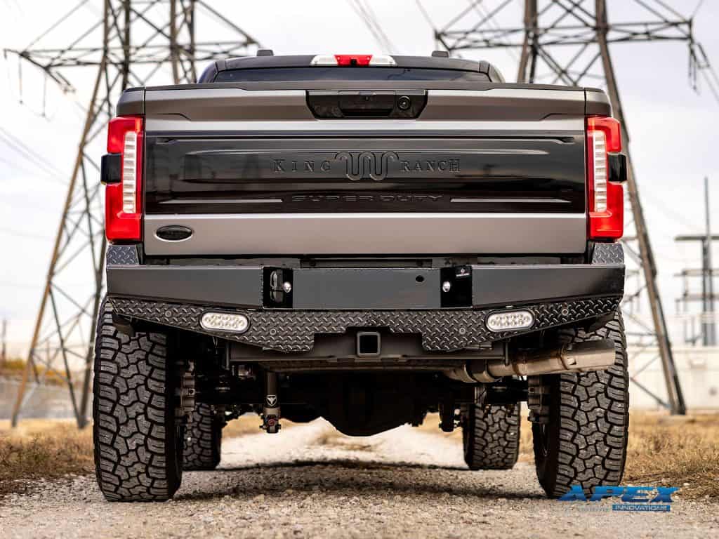Rear view of 2025 Ford F-350 King Ranch with Ranch Hand rear bumper, LED lights, and Yokohama all-terrain tires by Apex Custom Innovations